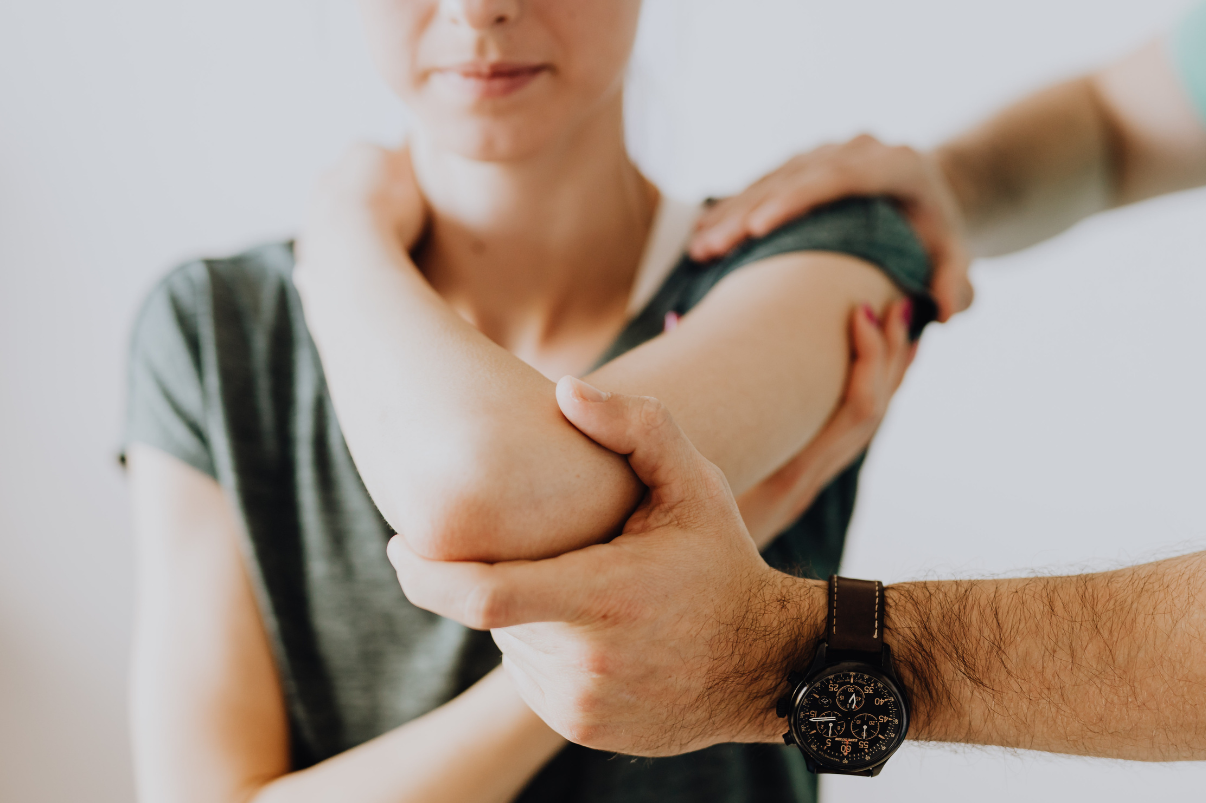 Physiotherapist assessing a woman’s shoulder movement