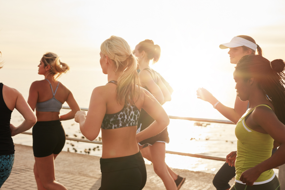 Group running together outdoors beside the beach