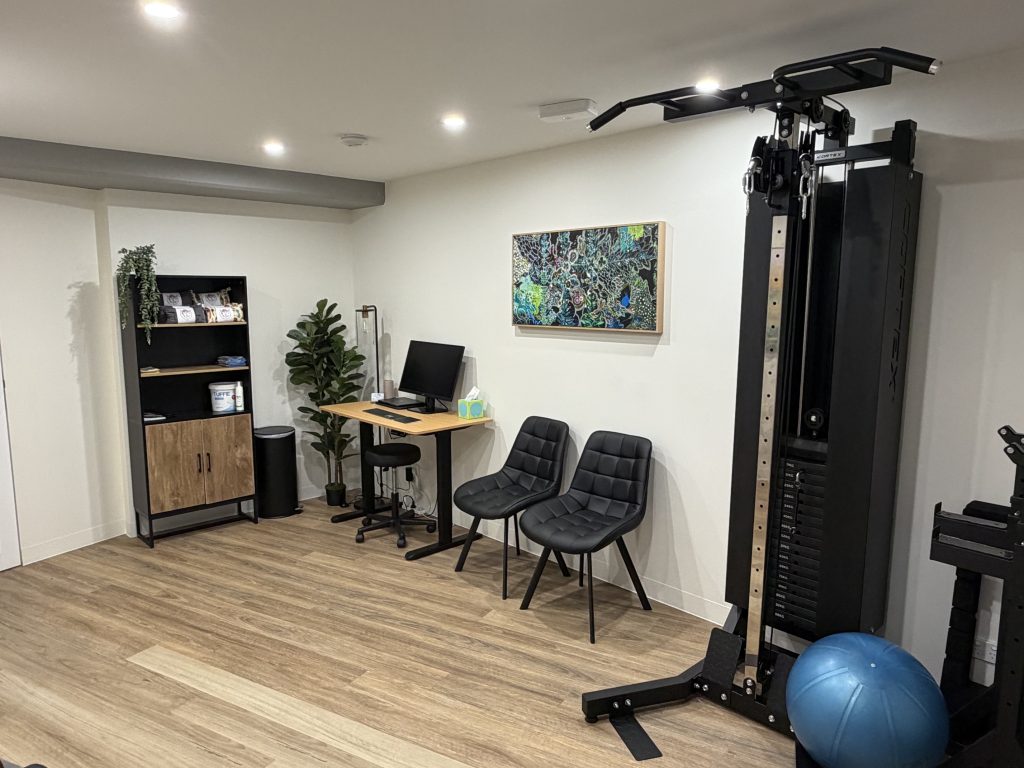 Physiotherapy clinic room with exercise equipment, consultation desk and seating
